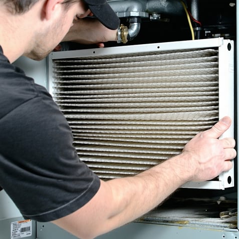 hvac technition changing a dirty air filter